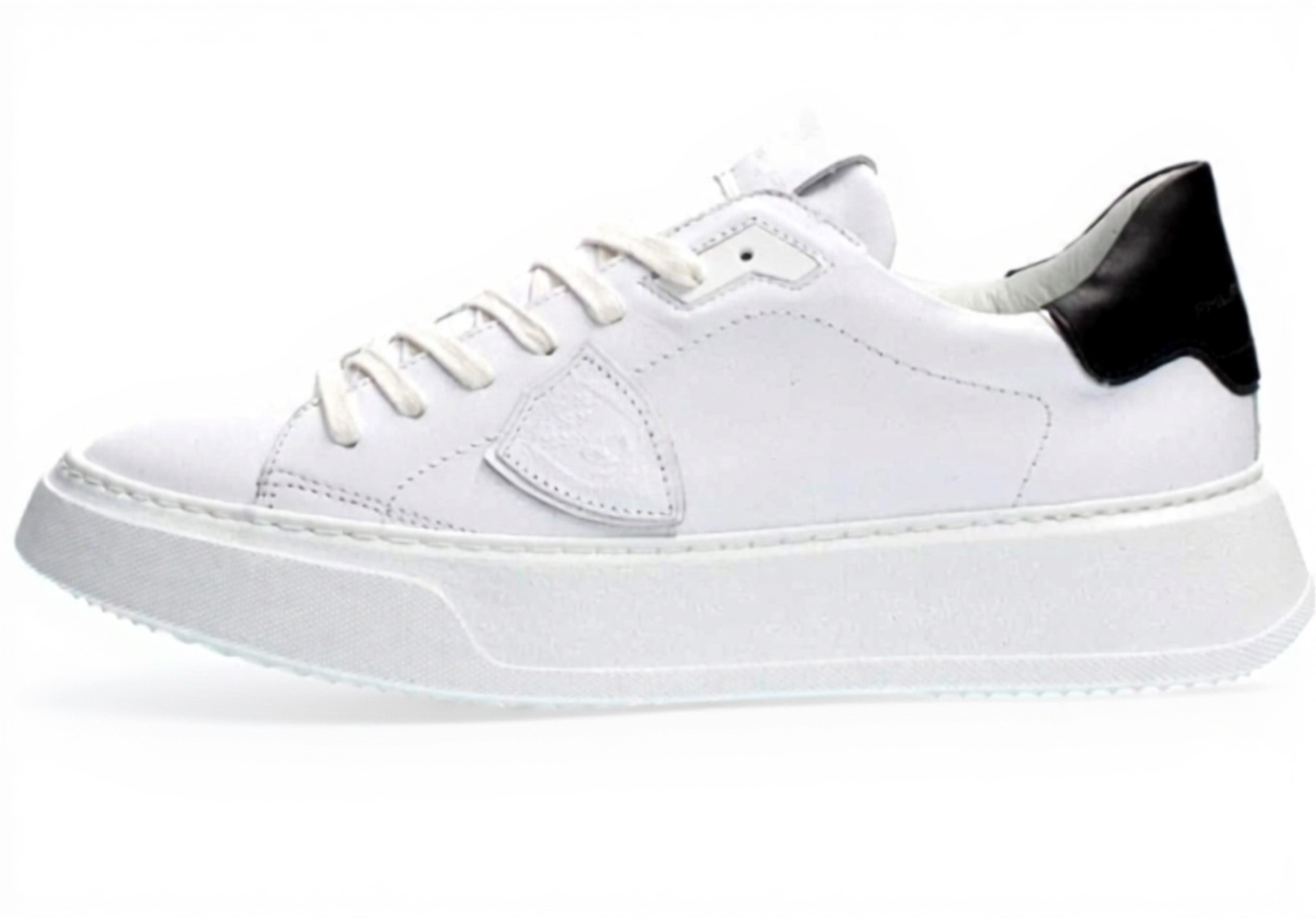 Philippe Model Herren Sneaker in Weiß mit schwarzen Akzenten auf grauem Hintergrund